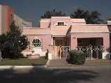 A pretty pink house with a one car garage.